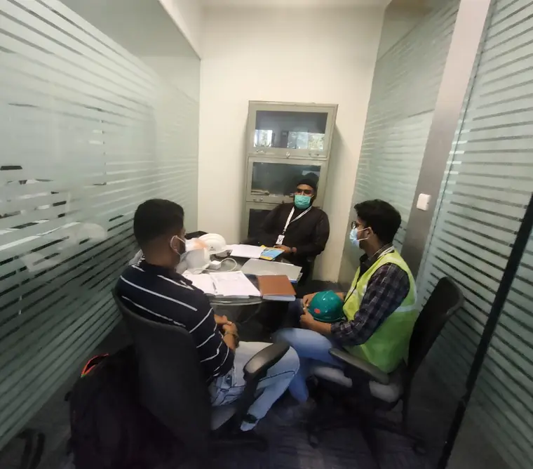 Auditors reviewing documentation with site staff around a table