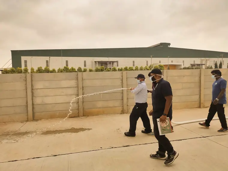 Fire hose being operated across an open yard during a mock drill