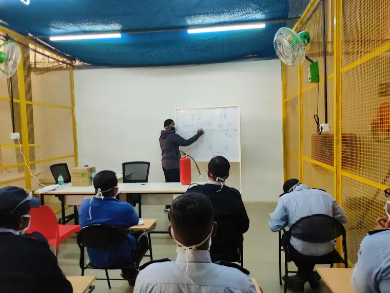 Trainer at a whiteboard leading a fire safety classroom session