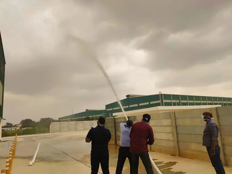 Trainees operating a fire hose during an outdoor emergency drill